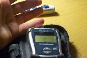 Test della glicemia con glucometro e striscia reattiva su un dito